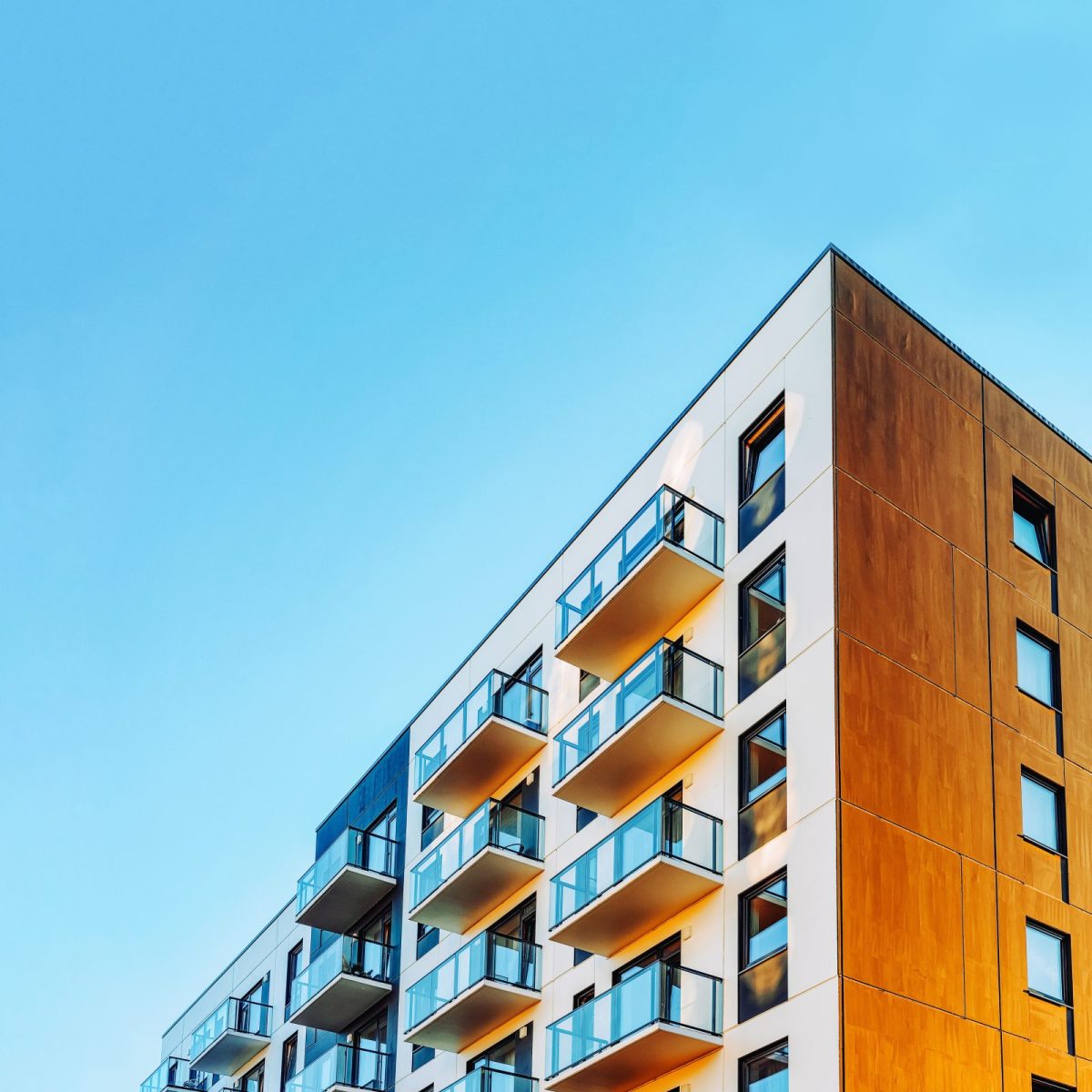 Part of Modern residential apartment with flat building exterior. Detail of New luxury house and home complex. Fragment of City Real estate property and condo architecture. Copy space. Blue sky